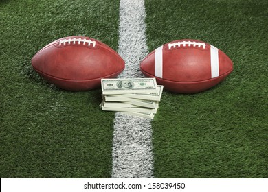 Pro And College Style Footballs With A Pile Of Money On The Line