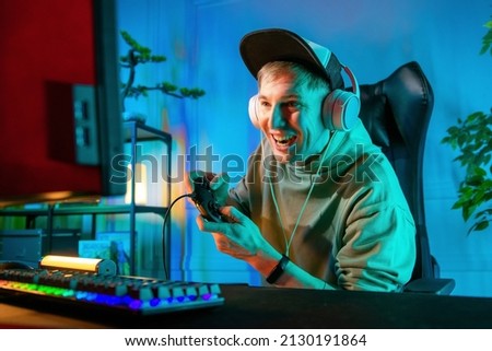 Pro Gamer Man playing computer games. Player using controller for virtual tournament gaming space shooter at home