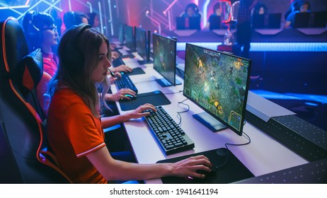 Pro Girl Plays Computer Game Plays RPG Strategy on a Championship. Diverse Esport Team of Pro Gamers Play in Mock-up Video Game. Stylish Neon Cyber Games Arena. Side View Shot - Shutterstock ID 1941641194