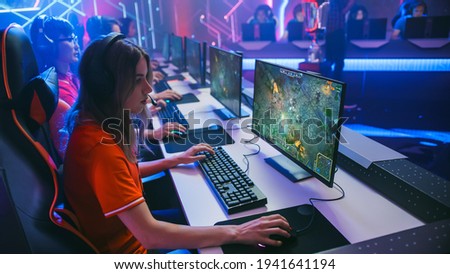 Pro Girl Plays Computer Game Plays RPG Strategy on a Championship. Diverse Esport Team of Pro Gamers Play in Mock-up Video Game. Stylish Neon Cyber Games Arena. Side View Shot