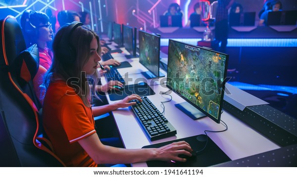 Pro Girl\
Plays Computer Game Plays RPG Strategy on a Championship. Diverse\
Esport Team of Pro Gamers Play in Mock-up Video Game. Stylish Neon\
Cyber Games Arena. Side View\
Shot