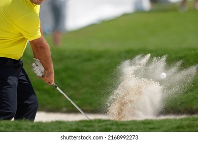 Pro Golfer Hitting A Sand Bunker Shot Wearing Yellow Shirt