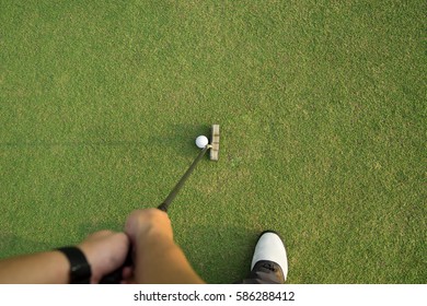 Pro Golfer Short Putting Golf Ball To Hole, Top View From Player Eye.