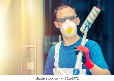 Pro House Painting. Professional House Painter With Painting Roller, Safety Mask And Glasses. Indoor Painting.