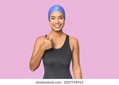 Pro Latina swimmer in studio gear smiling and raising thumb up - Powered by Shutterstock