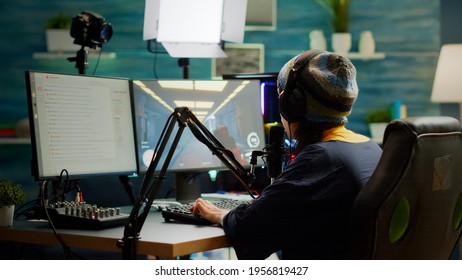 Pro Streamer Checking Sound On Mixer Putting On Headset And Start Playing FPS Video Game During Virtual Competition. Gamer Using Professional Streaming Setup, Stream Chat In Gaming Home Studio