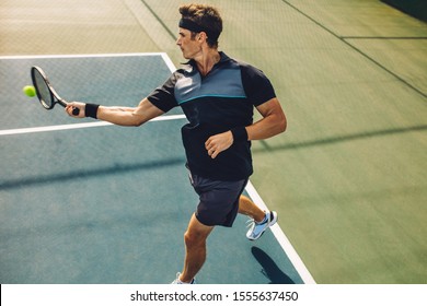 Pro Tennis Player Hitting Forehands On A Hard Court. Professional Tennis Player Practicing On A Hard Court.