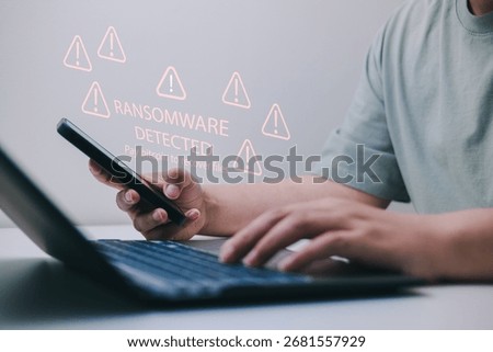Proactive ransomware defense concept with multiple warning icons on screen, user using phone and laptop, related to cyberattack, data encryption, file hostage, and digital extortion threats.