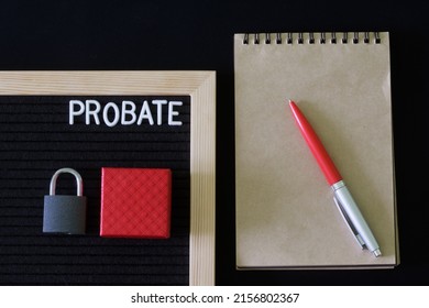 Probate Written On A Black Felt Board Next To A Notepad, Fountain Pen, Padlock And Gift Box. The Concept Of An Unexpected Inheritance And The Memory Of A Deceased Relative. Close-up.