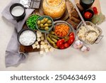 Probiotic food concept. Cabbage in jar, pickle, carrot on light wooden background. Top view