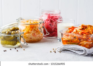 Probiotics Food Concept. Kimchi, Beet Sauerkraut, Sauerkraut, Kefir And Pickled Cucumbers In Glass Jars, White Background.