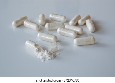  Probiotics. White Medicine Capsules Probiotic Powder Inside, One Capsule Open.