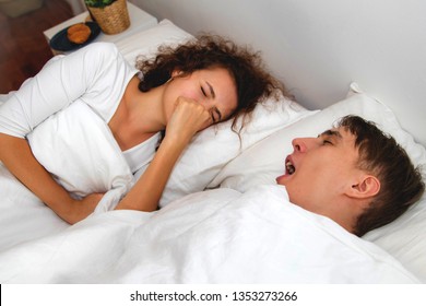 The Problem Of The Bad Breath Of A Young Man Creates A Nuisance For His Girlfriend During Sleeping Together Until Using His Hands To Close His Nose