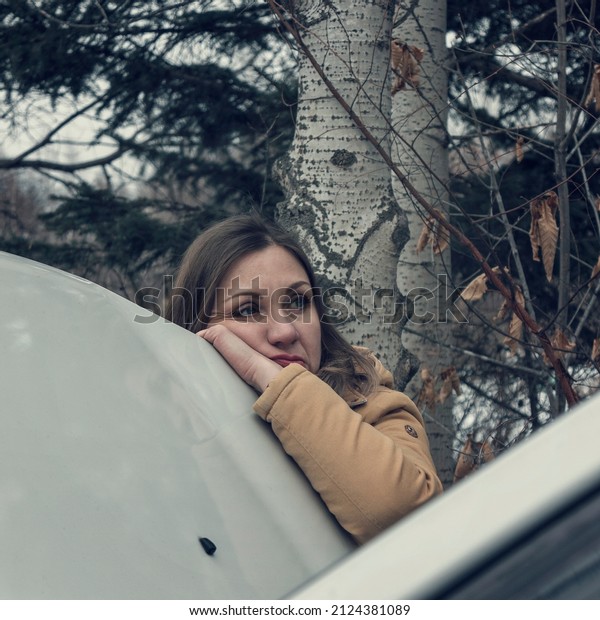 The problem with the car,\
breakdown. Winter forest, cold. Upset woman thinking what to do.\
Lifestyle.