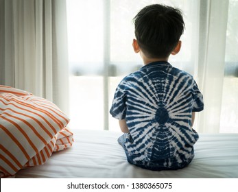 The Problem Of Child Development:A Little Boy Sitting By The Bed Looking Through The Window Absent-minded. Recognizing Developmental Delays In Children, Autism Awareness, Psychological Trauma Kids.