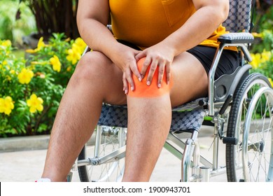 Problem Knee Pain Stressed With Overweight Or Obesity. Hand Of Fat Woman Touching Disease Her Knee Ache While Sitting On Wheelchair In The Garden. Healthy Care Concept.