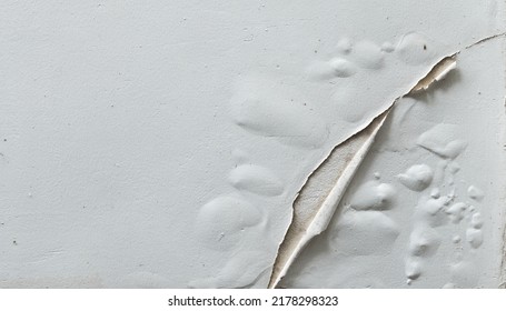 Problem of moisture damage acrylic white painting crack surface texture on exterior dirty stain concrete structure wall background by humidity.home repair old construction concept,renovation house. 