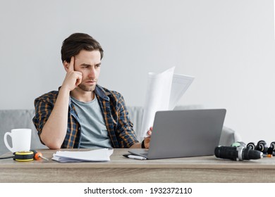 Problem With Order, Negative Emotions And Complicated Instructions, Handyman At Work. Serious Upset Attractive Young Man At Desk With Laptop And Tools For Repair Reading Instruction, Empty Space