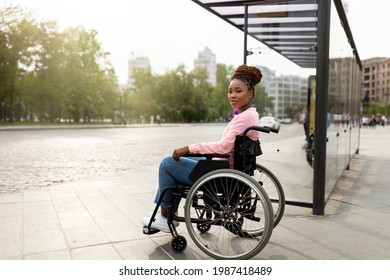 Problem of public transport for people with disabilities. Young black handicapped woman in wheelchair feeling stressed, cannot board vehicle suitable for impaired persons, waiting on bus stop