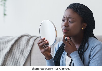 Problem Skin Concept. Black Woman Looking In Round Mirror And Touching Her Face, Worry About Pimple, Closeup