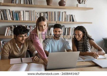 Problem solving and academic teamwork. Young gen z girl take lead with diverse team of multiethnic teenage students explain project on notebook screen to classmates group mentoring friends in learning