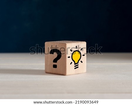 Problem solving, brainstorming, creative idea and finding a solution to a problem concept. Question mark and light bulb icons on wooden cube.