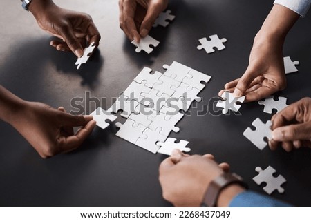 Problem solving as a dedicated team should. Closeup shot of a group of unrecognisable businesspeople joining puzzle pieces together in an office.