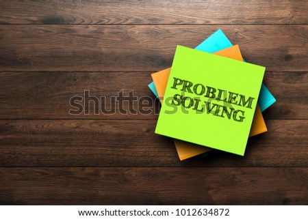 Problem Solving, the phrase is written on multi-colored stickers, on a brown wooden background. Business concept, strategy, plan, planning.