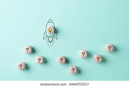 Problem solving and startup launch concept. A conceptual image of a rocket with a lightbulb taking off, surrounded by cubes with question marks on a light blue background. inspiration and innovation,