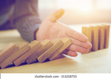 Problem Solving,businessman Stop Effect Of Dominoes Continuous Toppled With Hand At Desk,retro Style Image Executive And Risk Control Concept,selective Focus,vintage Color
