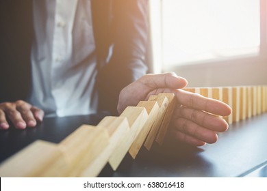 Problem Solving,Close up view on hand of business woman stopping falling blocks on table for concept about taking responsibility. - Shutterstock ID 638016418