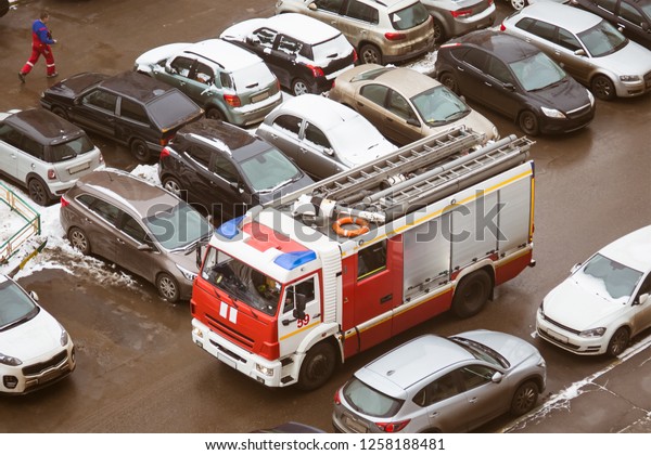 Problem. The special fire truck cannot drive in\
the courtyard of a multi-storey high-rise building because of\
parked cars. View from\
above.