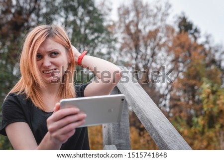 problems, indecision, service, what to do. emotions on the face what happens, woman using a smartphone. outdoor hiking travel. forest background. autumn day. communication, internet. copy space