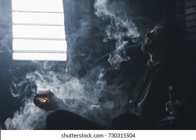 Problems in life. Career crash. Successful man lost everything, despair in alcohol and vaping. Tired bankrupt, depressed guy in smoke in dark room, bankruptcy concept