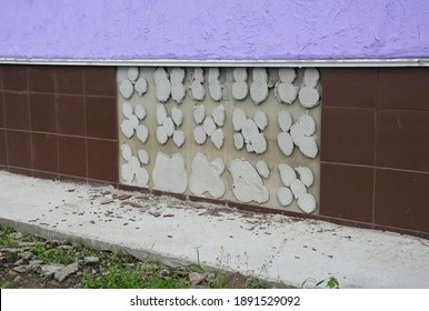 Problems With Waterproofing When Applying Tiles To The Siding Of Exterior Foundation Wall Of The House. Foundation That Needs Repairing With Tiles Fallen Off Because Of Bad Waterproofing. 