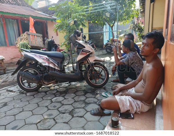 Probolinggo, East Java / Indonesia -\
March 30 th 2020: A black man, sitting with another\
colleague.