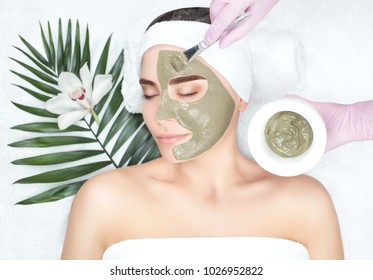 The procedure for applying a mask from clay to the face of a beautiful woman. Spa treatments and care of the face in the beauty salon. - Powered by Shutterstock