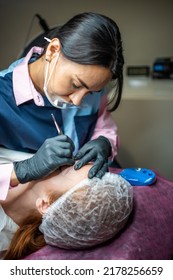 Procedure Of Eyebrow Microblading. A Master In Black Gloves Is Doing A Blending Needle Of Model's Brow. High Quality Photo