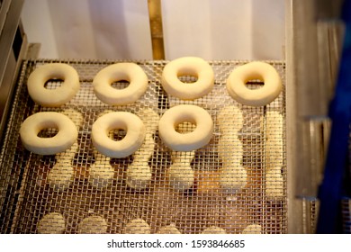 Procedure Of Making Donuts In A Small Town Donut Bakery - Donuts Preparing To Fry In A Deep Fryer. Scene. Process Of Preparation Of Donuts