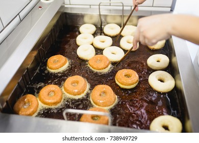 Procedure Of Making Donuts In A Small Town Donut Bakery - Donuts Frying In A Deep Fryer. Selective Focus. 