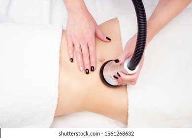 procedure removing cellulite on female abdomen, cavitation belly massage. Ultrasonic massage for weight loss. Correction of female figure without surgical intervention. Closeup of the tummy.