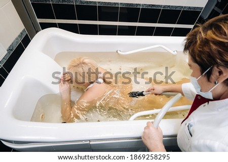 the procedure of underwater shower massage in the bathroom.Girl on the procedure of underwater massage