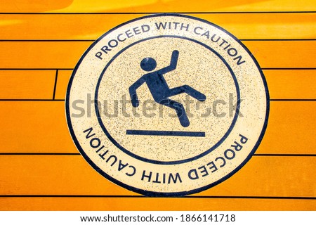 Proceed With Caution sign to alert of slippery floor showing symbol of person falling to the ground.
