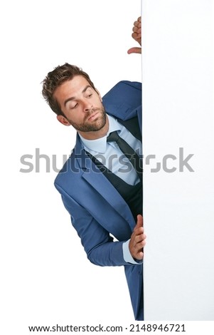 Proceed with caution. Studio shot of a handsome businessman peering around a wall against a white background.