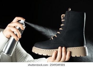 The process of applying a water-repellent protective agent from a spray can to a boot.