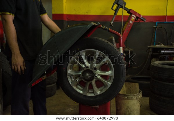 A process balance of\
new tire replacement at service station, mechanic changing a wheel\
and tires