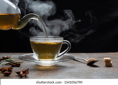 Process Brewing Tea,dark Mood.The Steam From Hot Tea Is Poured From The Kettle Into A Kettle With Tea Leaves Redcurrant Mandarin Orange Lemon,rosemary, Mint.,hot Food And Healthy Meal Concept