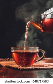 Process brewing tea,tea ceremony,Cup of freshly brewed black tea,warm soft light, darker background.