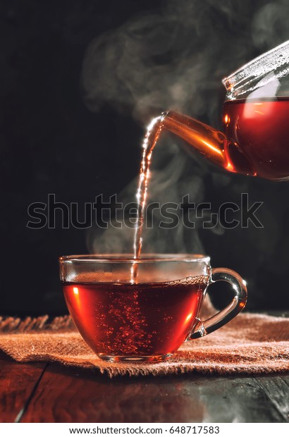 Process brewing tea,tea
ceremony,Cup of freshly brewed black tea,warm soft light, darker
background.