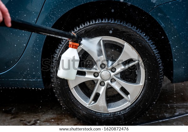The Process Of Car Washing. Spray shampoo with\
foam bubbles on the car\
wheels.